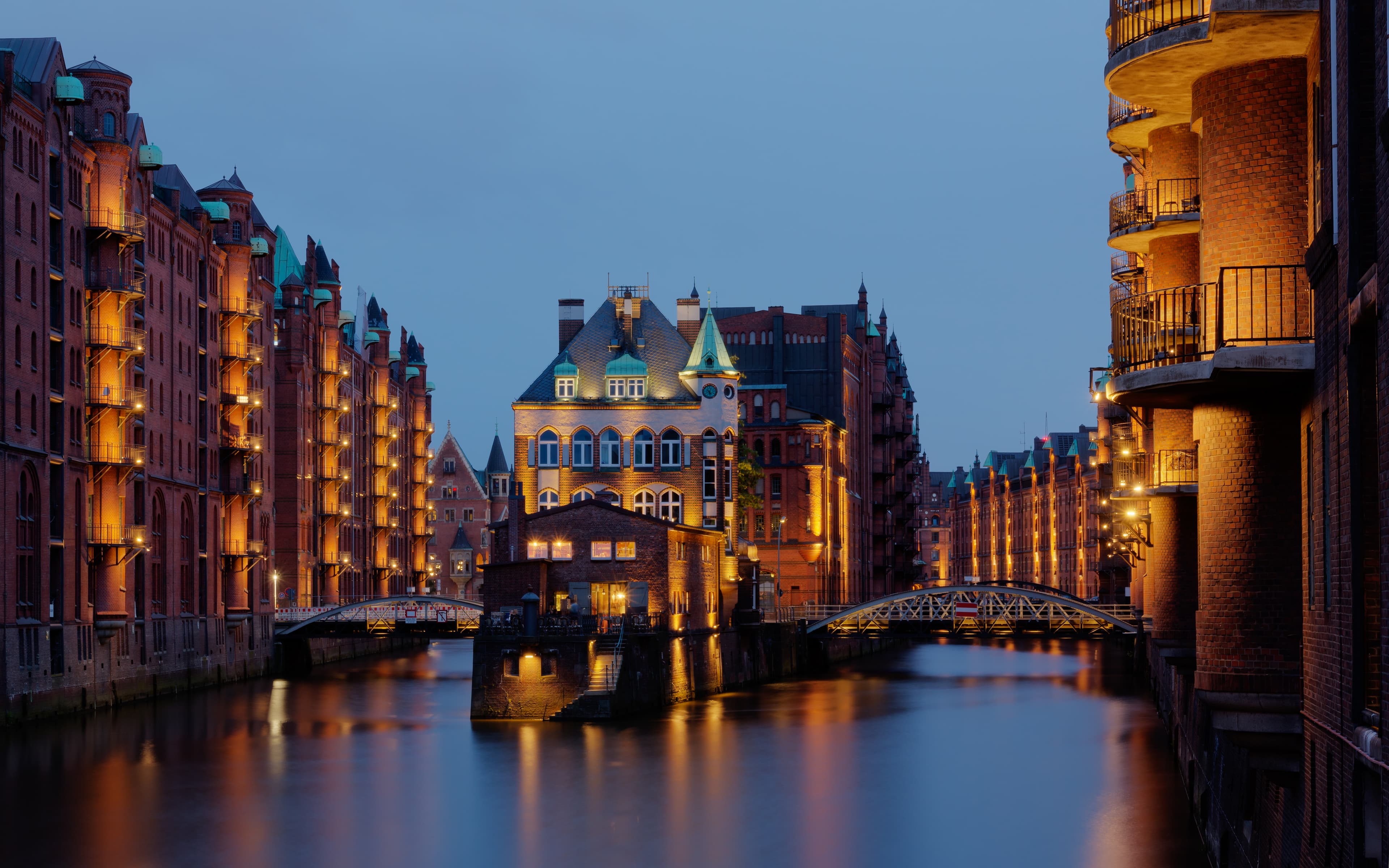 Hamburg’s illuminated Wasserschloss reflected in the Speicherstadt canal at blue hour