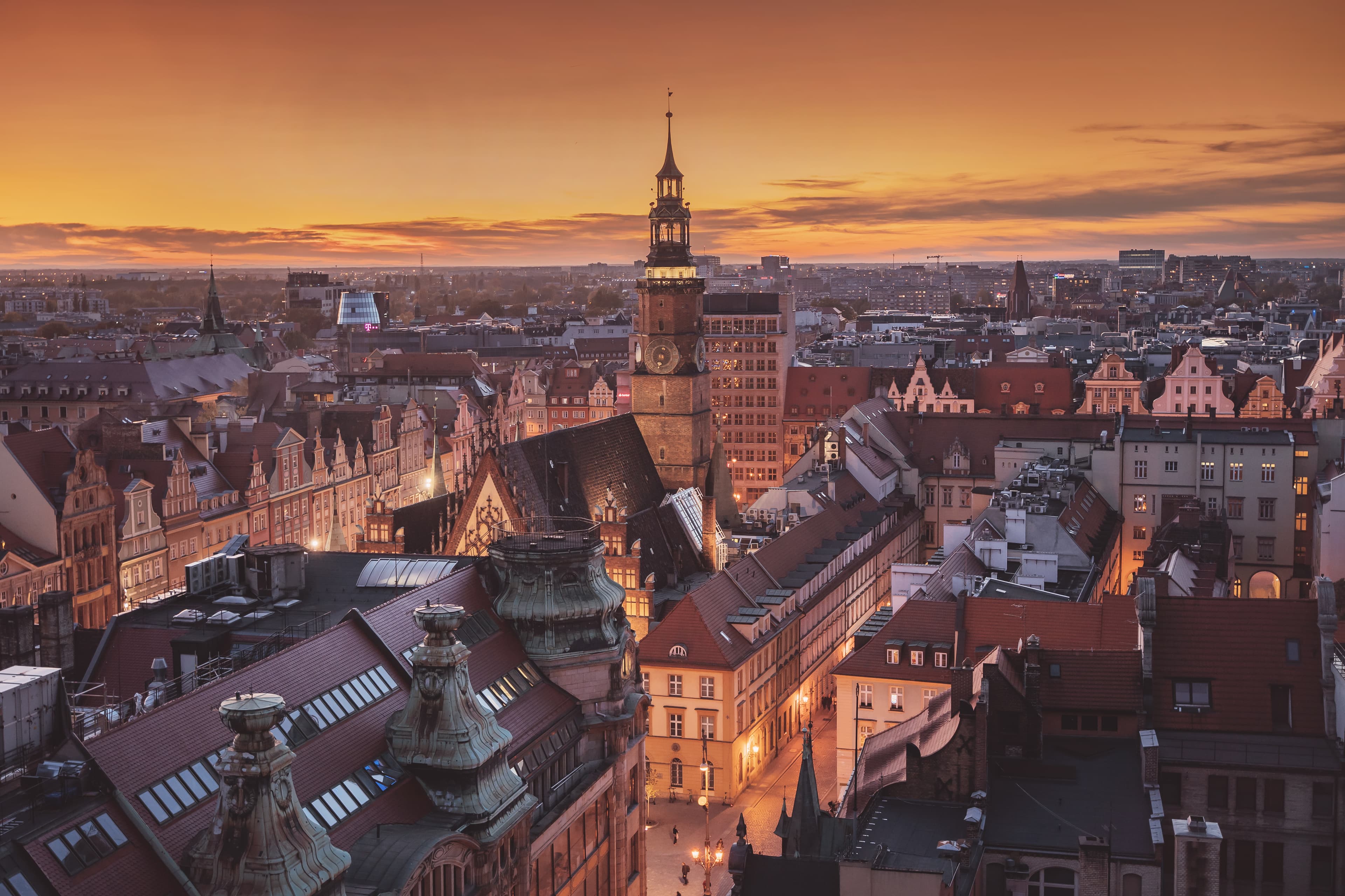 Wrocław’s town hall and historic rooftops beneath a golden sunset